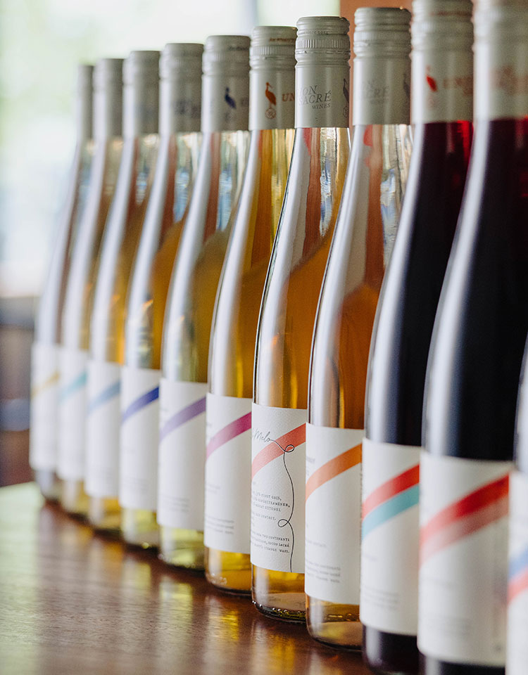 Bottles of reserve wines on the bar showing a rainbow of label colors.